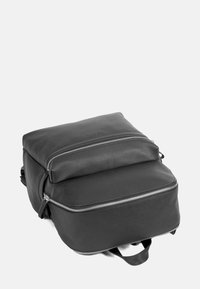 Svart läderryggsäck med en strukturerad design, texturerad yta, två blixtlåsfack och justerbara remmar.