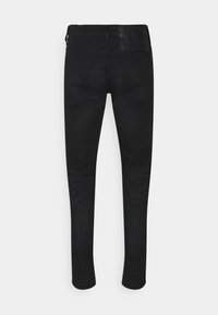 Black denim jeans with a slim fit. Features a leather waistband patch and two back pockets. Smooth texture with minimal stitching details.