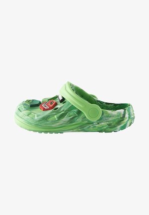 Zoccolo verde realizzato in materiale leggero con un motivo marmorizzato. Presenta una fascia regolabile e tre ciondoli decorativi sulla parte superiore.
