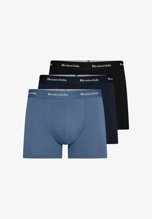 Hellblaue Boxershorts mit enger Passform, weichem Stoff und einem kontrastierenden Gummibund mit weißer Schrift. Modell steht barfuß und neutral.