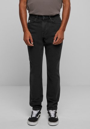 Black denim jeans with a straight-leg cut, featuring a classic five-pocket design and a small logo patch on the front pocket.