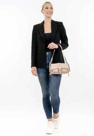Svart kavaj, åtsittande svart topp, blå skinny jeans, vita sneakers och en ljusrosa handväska med framfickor och axelrem.