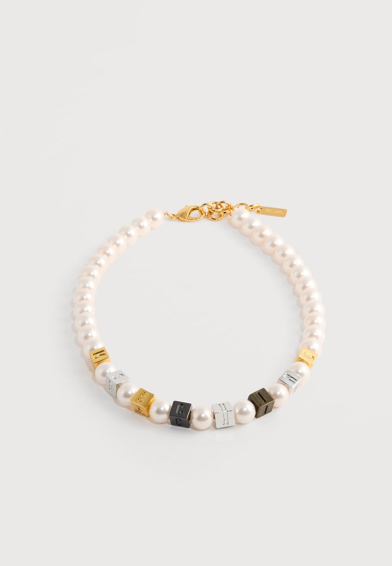 Collier de perles composé de perles blanches et de perles métalliques carrées en tons or, argent, noir et gris. Fermoir doré avec un détail d'étiquette de marque.