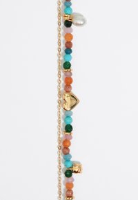 Bracciale con perline di pietre colorate assortite (turchese, arancione, verde) e un accento a forma di cuore dorato, con catene e perle.
