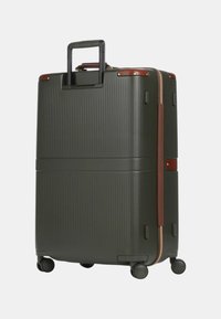 Valigia rigida di colore verde scuro con texture a righe verticali. Presenta dettagli in pelle marrone, manico retrattile e quattro ruote per la mobilità.