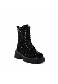 Czarne zamszowe botki za kostkę na grubej podeszwie, ozdobione metalowymi ćwiekami, z okrągłym noskiem i czarnymi sznurówkami. Chropowata cholewka o gładkim wykończeniu.