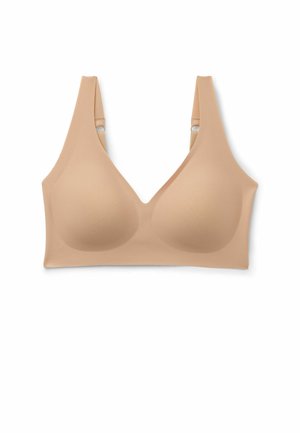 Naadloze beige draadloze beha met gevormde cups, brede verstelbare bandjes en een gladde afwerking op een witte achtergrond.