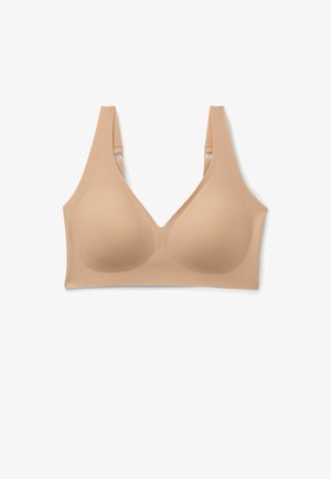Nahtloser beiger kabelloser BH mit geformten Körbchen, breiten verstellbaren Trägern und glatter Oberfläche vor weißem Hintergrund.