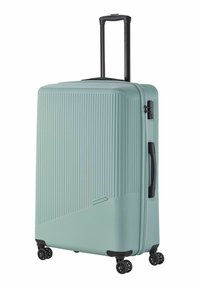 Valise rigide bleu clair avec des rayures verticales texturées, une poignée télescopique, quatre roues noires et une poignée de transport latérale.