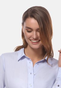 Hellblaue Button-up-Bluse mit glatter, knitterfreier Textur. Sie verfügt über einen klassischen Kragen und dunkle Knöpfe entlang der Leiste.