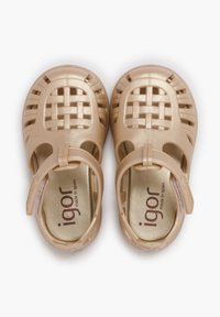 Tan plastic sandals featuring a woven design, an adjustable strap, and a smooth finish with a small logo on the insole.
