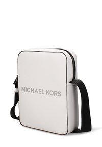 Borsa a tracolla in pelle bianca con chiusura a zip, bordi neri e logo argentato "MICHAEL KORS" ben visibile sul davanti. Tracolla regolabile inclusa.