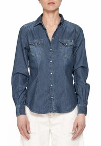 Camicia in denim con colletto classico, maniche lunghe, due tasche sul petto, colore azzurro chiaro e chiusura con bottoni arricchita da dettagli di cucitura discreti.