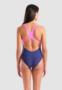  bañador de una pieza con parte superior rosa y parte inferior azul marino. Presenta un diseño de espalda nadadora, corte en la espalda y tela suave y elástica.