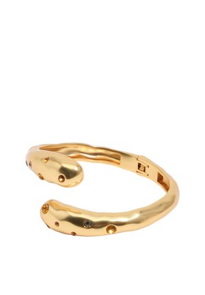 Otvorený zlatý náramok s vloženými jantárovými a hnedými drahokamami, so štýlom mierne nepravidelných vlniek a zapínaním na záves.