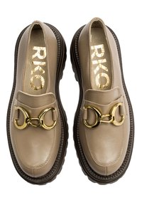 Beżowe skórzane mokasyny z błyszczącym złotym łańcuchem i teksturowaną czarną gumową podeszwą. Posiadają okrągły czubek i wyściełaną wkładkę.