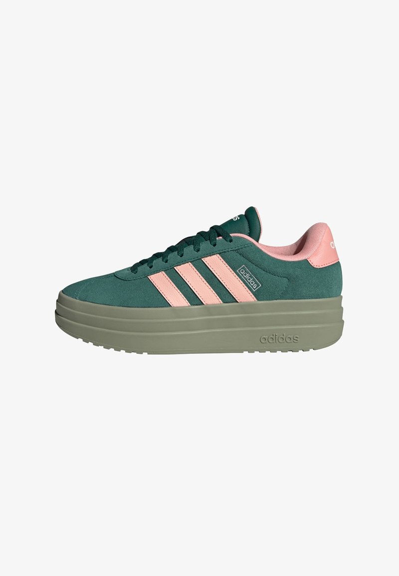 Baskets Adidas en daim vert avec des bandes roses, semelle épaisse beige et doublure intérieure rose. Chaussure décontractée d'extérieur avec lacets visibles.