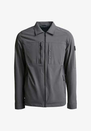 Harmaa vetoketjullinen takki, joka on valmistettu pehmeästä kankaasta. Siinä on kaulus, kaksi etutaskua, vetoketjullinen rintatasku ja vähäiset metalliset yksityiskohdat.