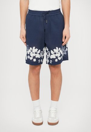 Marineblå bomullsshorts med hvitt blomstertrykk langs kanten, elastisk midjebånd med snøring og sidelommer.