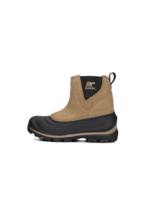 Botte d'hiver imperméable beige avec une semelle en caoutchouc noir, tige texturée, une languette de traction et le logo Sorel sur le côté. Semelle épaisse pour une bonne adhérence.