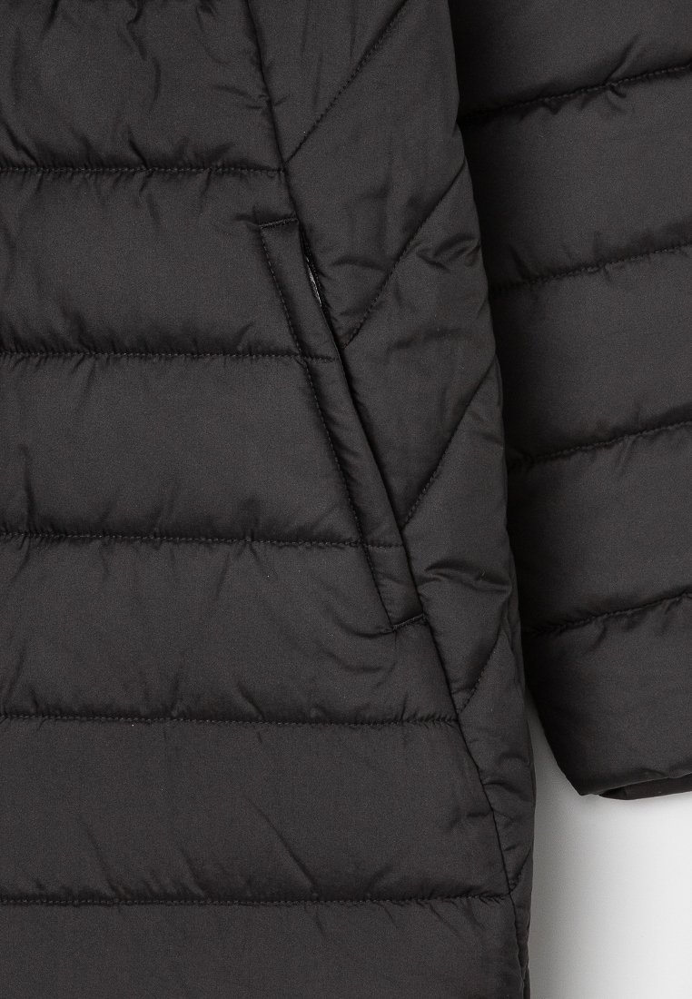 Schwarze, gestepfte Jacke mit Ärmel und seitlicher Tasche, die horizontale und diagonale Steppdetails auf glattem Stoff aufweist.