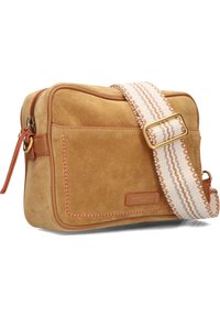 Suède schoudertas in bruin met oranje accenten. Kenmerkt zich door een dikke geweven schouderband met beige en bruine strepen en een voorvak met rits.