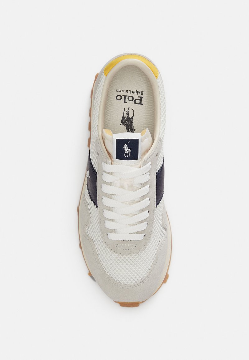 Baskets en mesh blanc avec accent marine, détails en daim et semelle en caoutchouc. Elles présentent des lacets blancs et un logo sur la languette.