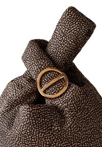 Brown patterned fabric bag with a gold circular logo detail. The material is soft, and the design features a knotted shape.