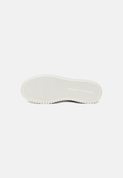 Semelle de chaussure en caoutchouc blanche avec grip texturé et motif de bande de roulement rectangulaire sur un fond gris clair uni.