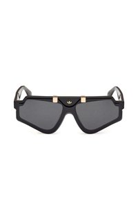 Occhiali da sole neri con una forma ampia e angolare, dotati di lenti scure e dettagli in oro sul ponte. Bracci neri texture.