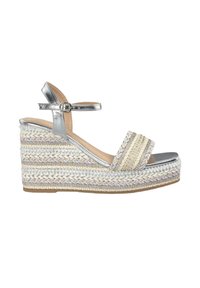 Sandalia de cuña con una tira metálica plateada, parte superior de tejido trenzado en beige y blanco, con acentos texturizados y una suela de plataforma.