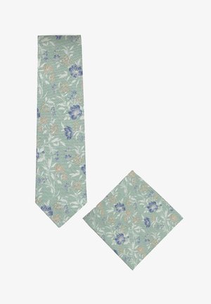 Ensemble cravate et pochette vert clair avec motifs floraux bleus, beiges et blancs sur tissu texturé.