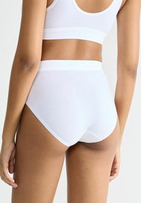Weiße Baumwoll-Hochbundsl panties mit einem weichen elastischen Bund, der eine glatte Textur und saubere Nähte für Komfort bietet.