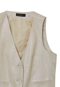 Gilet sans manches beige avec un décolleté en V, deux boutons et une légère brillance. L'intérieur est doublé d'un tissu léger et lisse.
