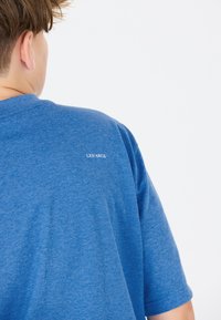 Blå kortærmet t-shirt i et blødt, struktureret stof med et lille hvidt "LES ARCS" logo på den øvre ryg.