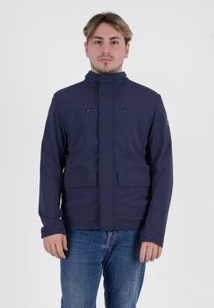 Giacca impermeabile blu navy con colletto alto, tasche con zip e una texture liscia. Caratteristiche includono maniche lunghe e tessuto resistente.
