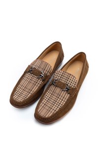 Mocasines de ante marrón que presentan un patrón de pata de gallo en la parte frontal, con un acento de herrajes metálicos negros y un diseño de punta redonda.