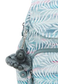 Teal ryggsäck med ett lövmönster i vitt och rosa. Har en plyschapa som nyckelring och grå dragkedjedetaljer. Tillverkad av hållbart material.