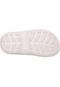 Biała gumowa podeszwa buta z teksturowanym wzorem chwytu, wyposażona w głębokie rowki i wyraźne logo. Zaprojektowana dla przyczepności i komfortu.