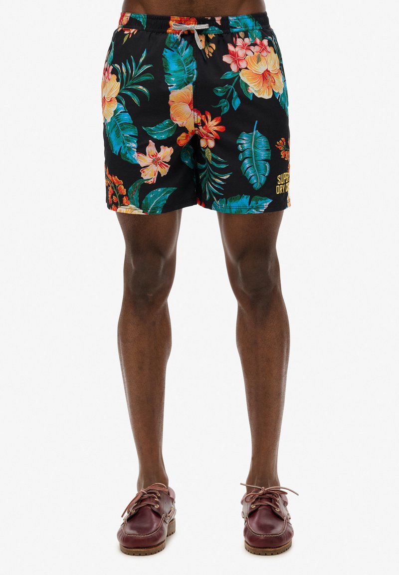 Shorts de baño negros con estampados tropicales brillantes, cinturilla elástica con cordón y un pequeño logo en la pierna.