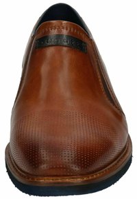 Braune Leder-Slipper mit runder Zehenpartie, durchbrochenem Design auf der Zehenkappe und schwarzem Akzent im oberen Bereich.