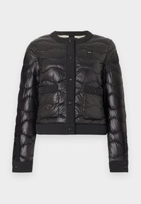 Μαύρο καπιτονέ μπουφάν με κουμπιά πατιλέτας, δύο εμπρόσθιες τσέπες με καπάκι και στρογγυλό γιακά, σε λευκό φόντο.