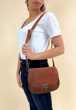 Borsa a spalla in pelle marrone con patta arrotondata, chiusura metallica e tracolla regolabile. Design semplice e texture liscia.