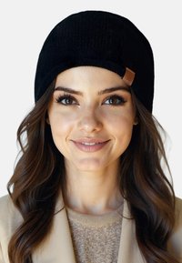 Gorro de punto negro con un dobladillo y una pequeña etiqueta de cuero marrón en el lado. Material texturizado y suave con un ajuste ceñido.