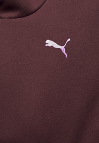 Bordeaux sweatshirtstof met een gladde textuur. Heeft een lichtroze puma-logo in een sprongetje op de borst.