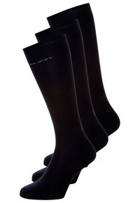 Drei Paare kniehoher Socken in Schwarz, mit einer glatten, undurchsichtigen Strickstruktur und einem gerippten oberen Bündchen. Dezente Markenkennzeichnung nahe der Oberkante.