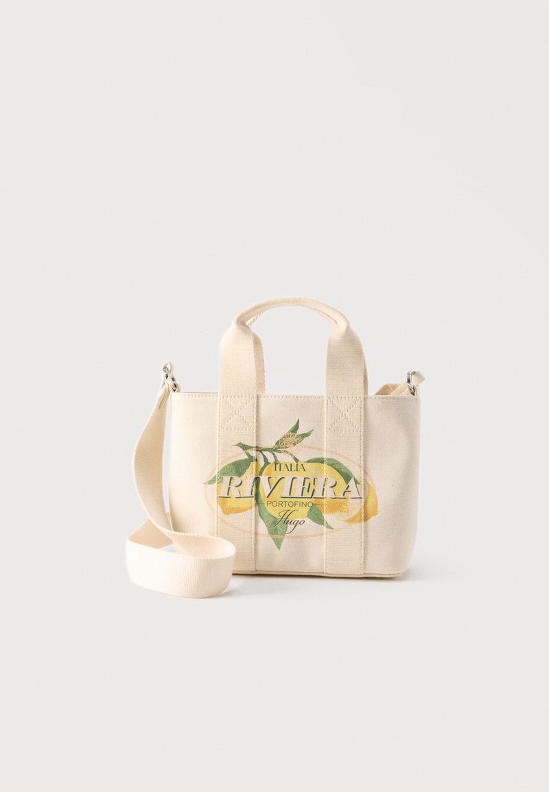 Petit sac en toile beige avec des poignées courtes et une longue bandoulière, présentant un citron et le texte « Italia Riviera Portofino Hugo » sur le devant.