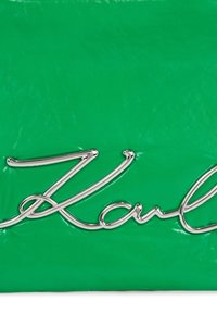 Groene glanzende clutch met een opvallend zilveren signatuurlogo. Gladde textuur met een gestructureerde vorm.