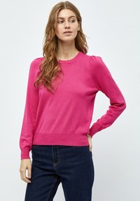 Maglione fucsia a maniche lunghe con collo a girocollo, caratterizzato da spalle leggermente a sbuffo, polsini a coste e vita aderente. Il tessuto appare liscio.