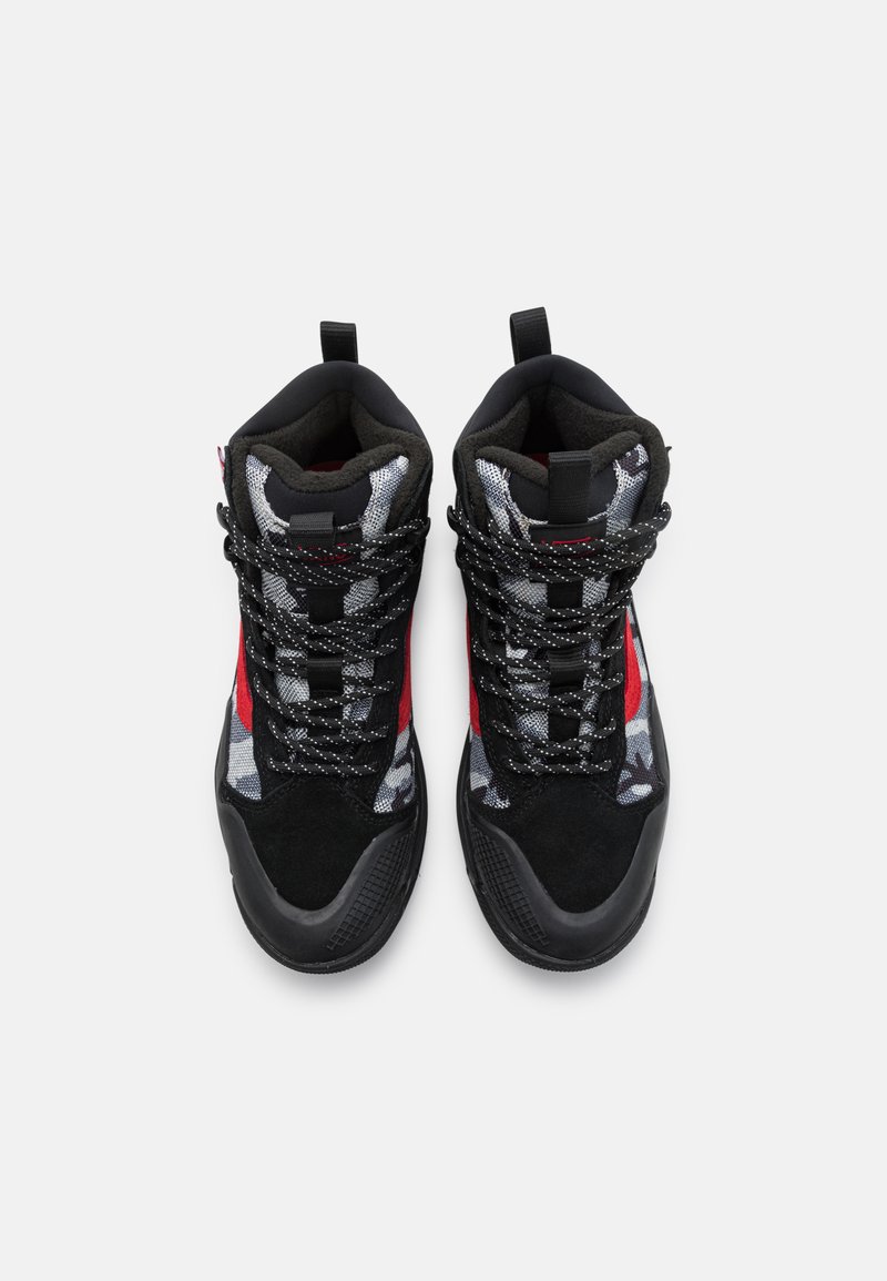 Zapatillas altas con una combinación de colores negro y rojo, que presentan materiales de tela y ante, patrones de camuflaje y suelas texturizadas.